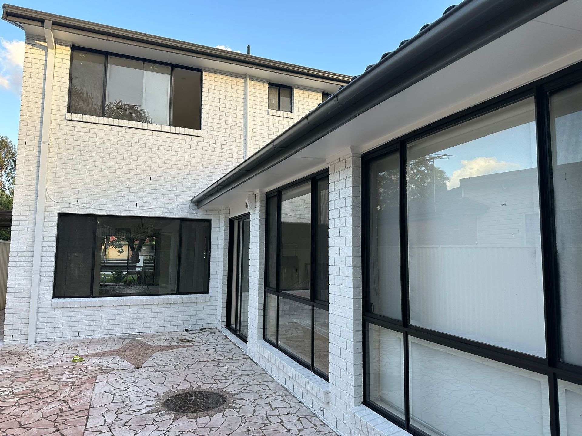 A white brick house with a lot of windows
