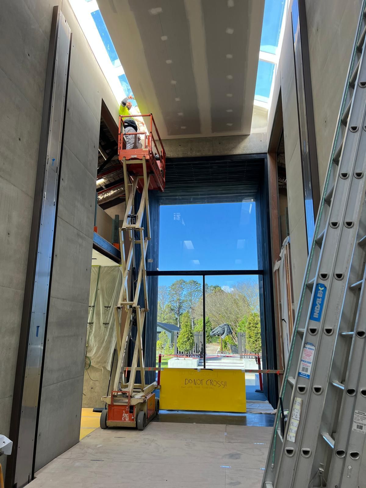 A man is standing on a lift in a building under construction.