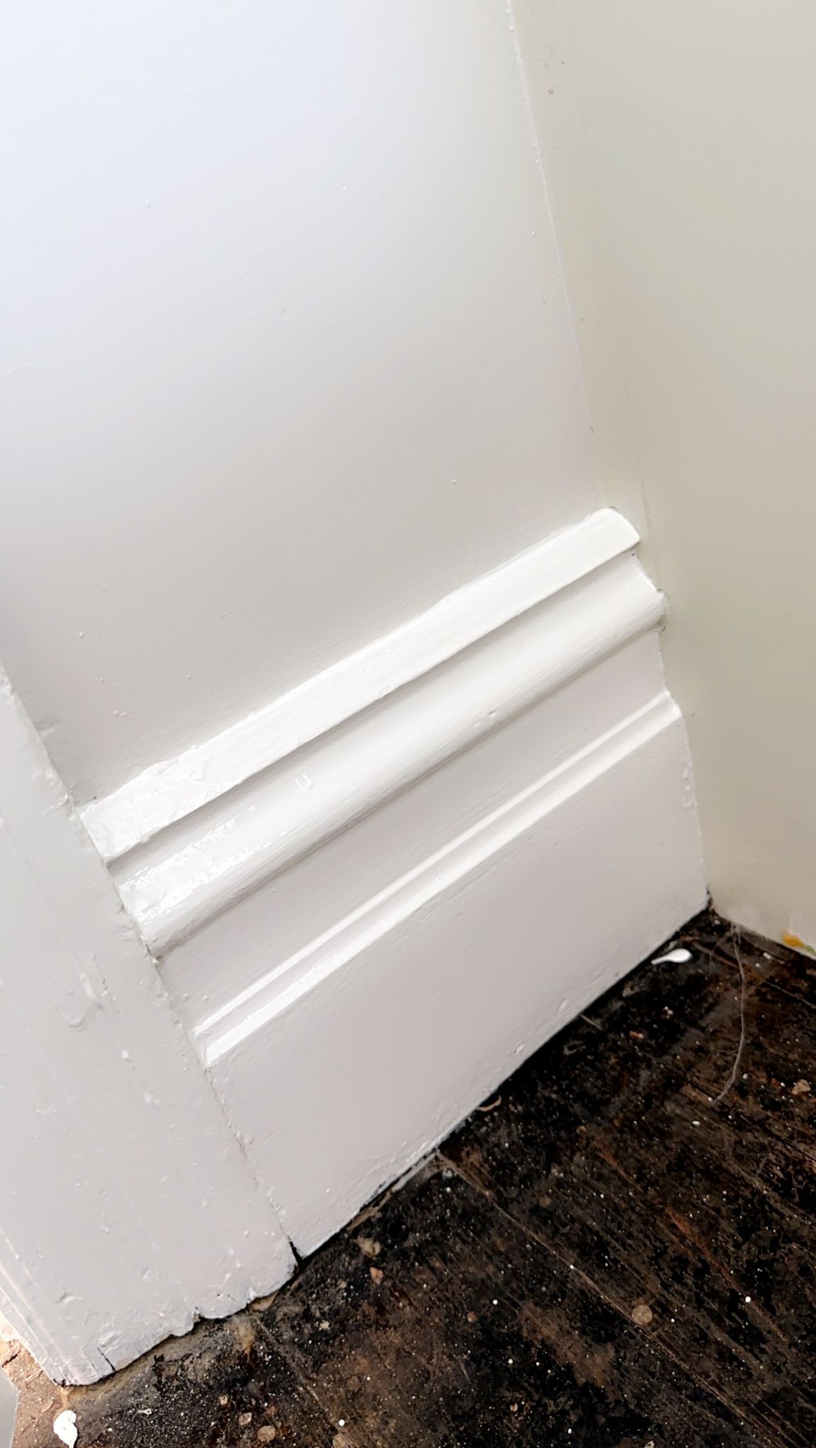 A close up of a white molding on a wall in a room.