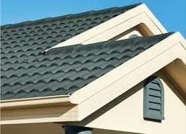 A close up of a roof of a house with a blue sky in the background.