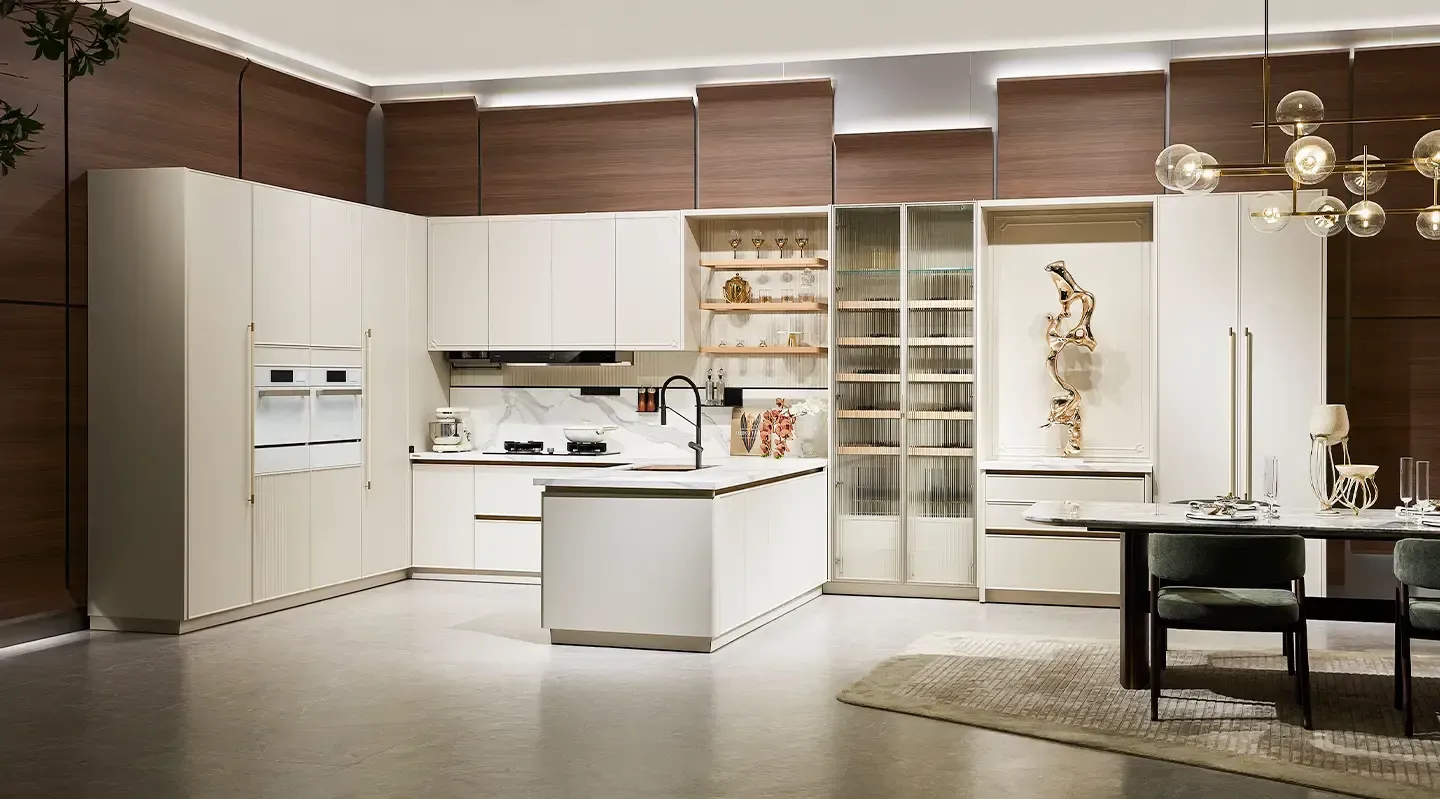 A kitchen with white cabinets , a table and chairs.
