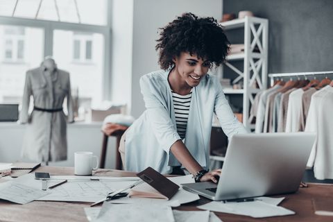 happy woman typing on a laptop