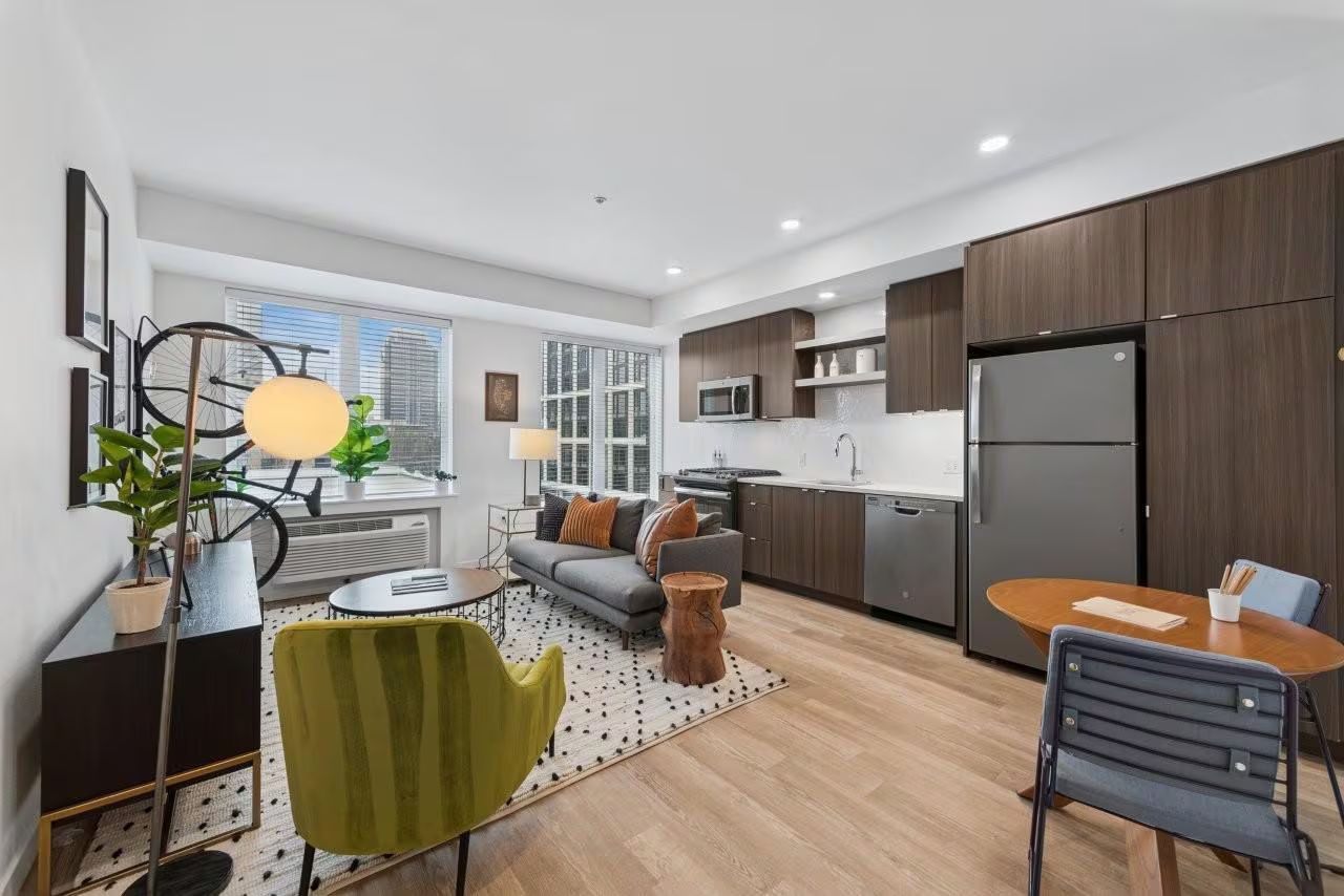 Modern apartment interior with living and dining areas, kitchen, and balcony.