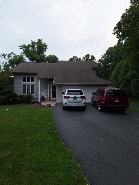 Suburban house with two cars parked in the driveway on a cloudy day