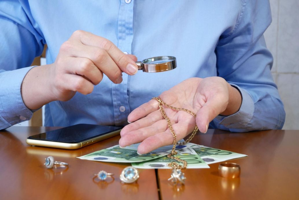 A person is looking at a necklace with a magnifying glass.