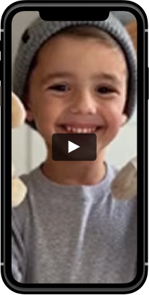 A smiling child wearing a gray knit beanie and matching long-sleeved shirt is shown in a mobile video interface.