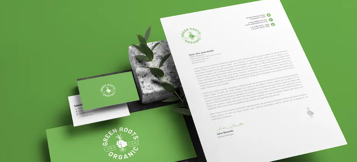 Stationery set with a green and white logo, including a letterhead, business cards, and a stone on a green background.