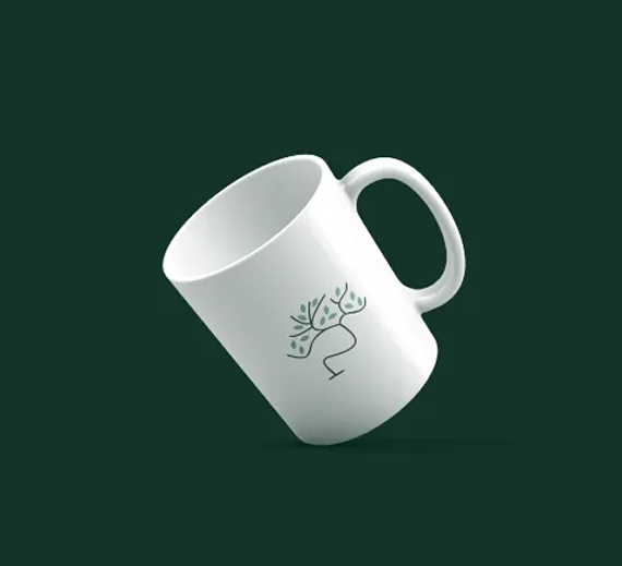 A white mug tilted against a dark green background, featuring a simple black line drawing of a tree on its surface.