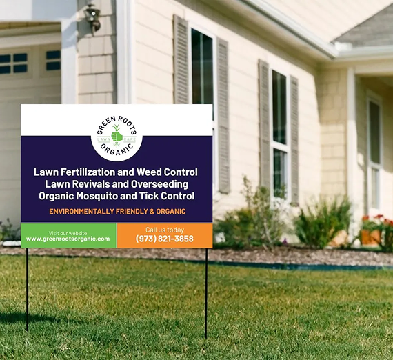 A lawn sign for Green Roots Organic, listing services in front of a house.