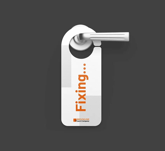 A white, glossy door hanger on a door handle with the orange word 