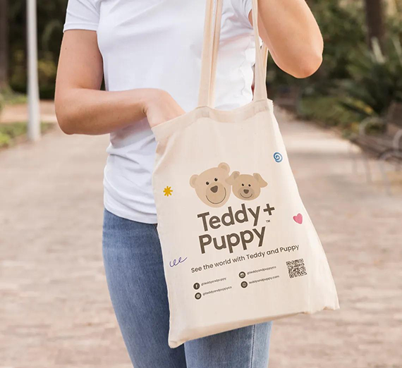 A person carries a cream canvas tote bag with a 