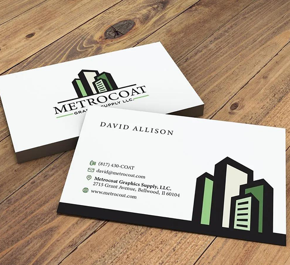 A business card for MetroCoat Graphics Supply, showing David Allison's contact info, on a wooden surface.