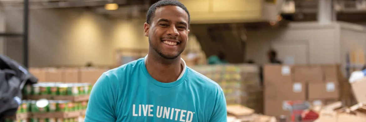 A smiling person wearing a blue 