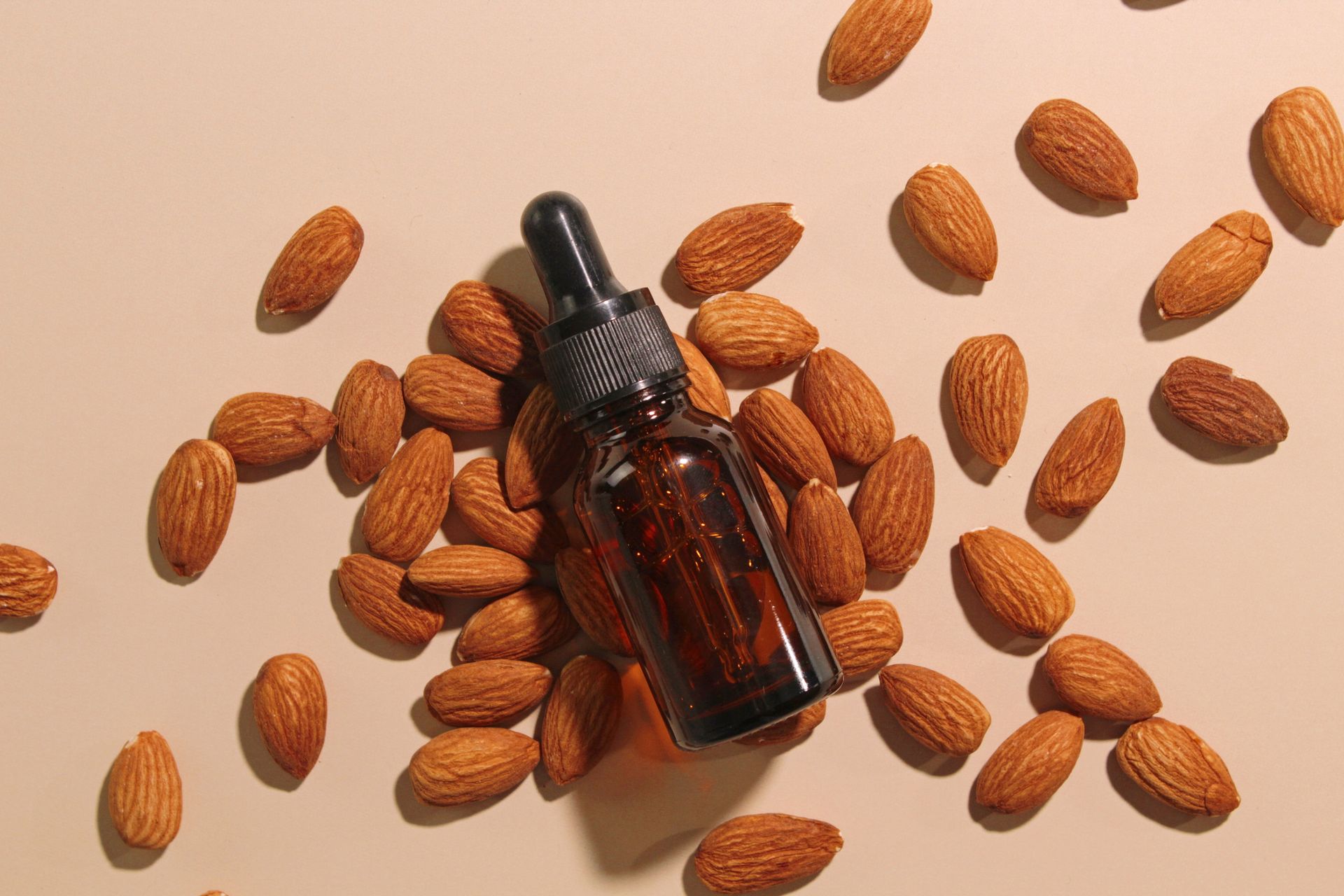 A woman is smiling while applying a cream to her face.