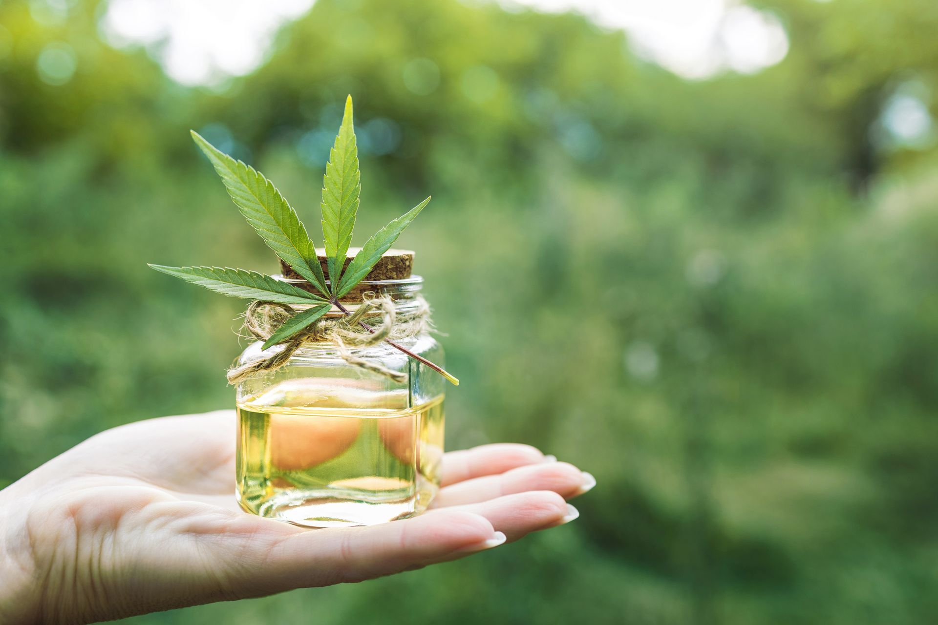 A woman is smiling and touching her face with her hand.
