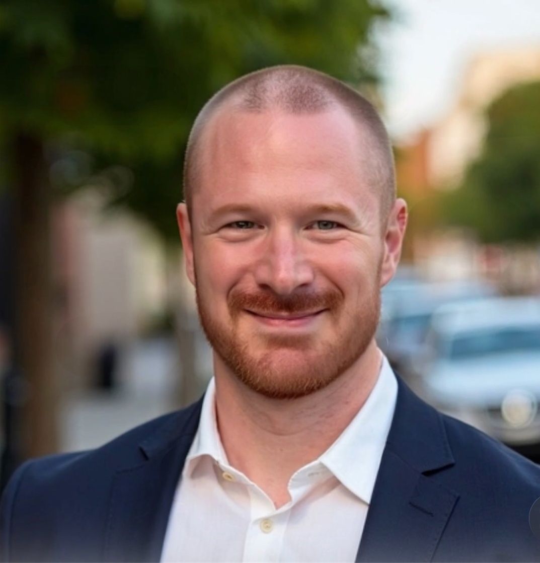 A man and a woman are sitting on a dock overlooking a lake.