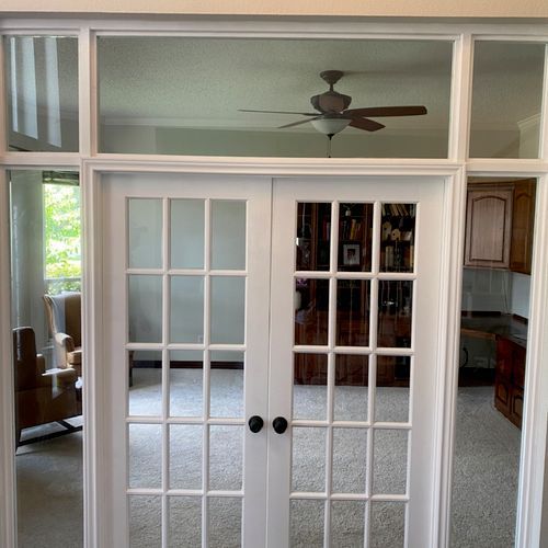 A living room with a ceiling fan and french doors