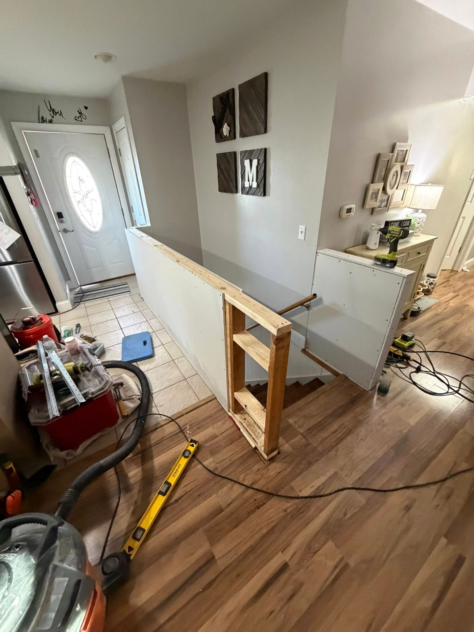 Construction site: Interior view of stairs being renovated. Drywall and wooden shelf partially installed.