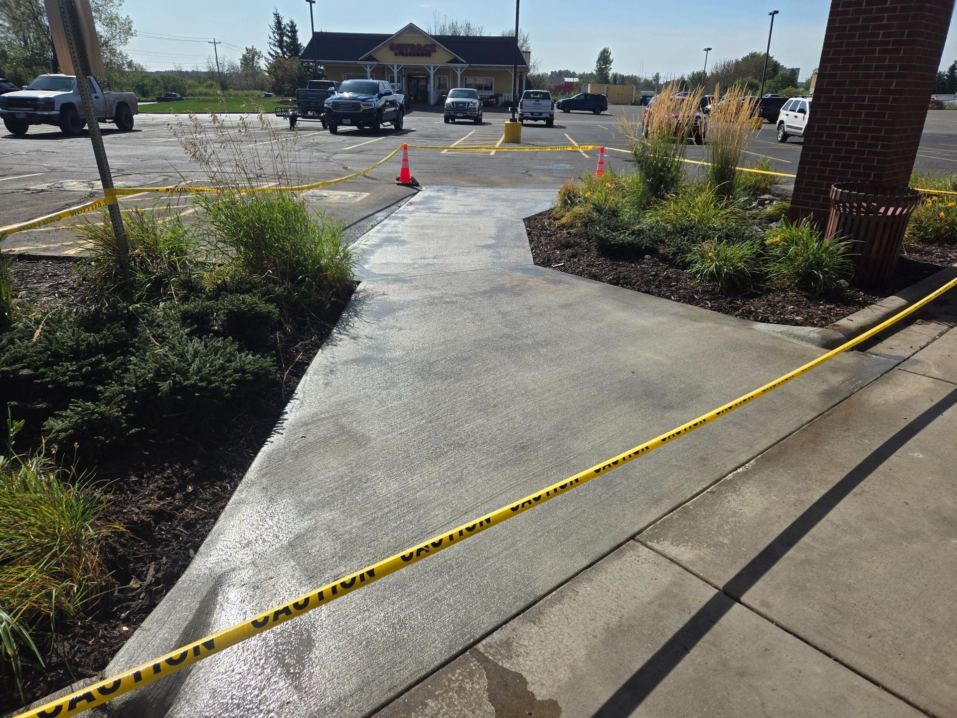 A concrete walkway is surrounded by yellow caution tape