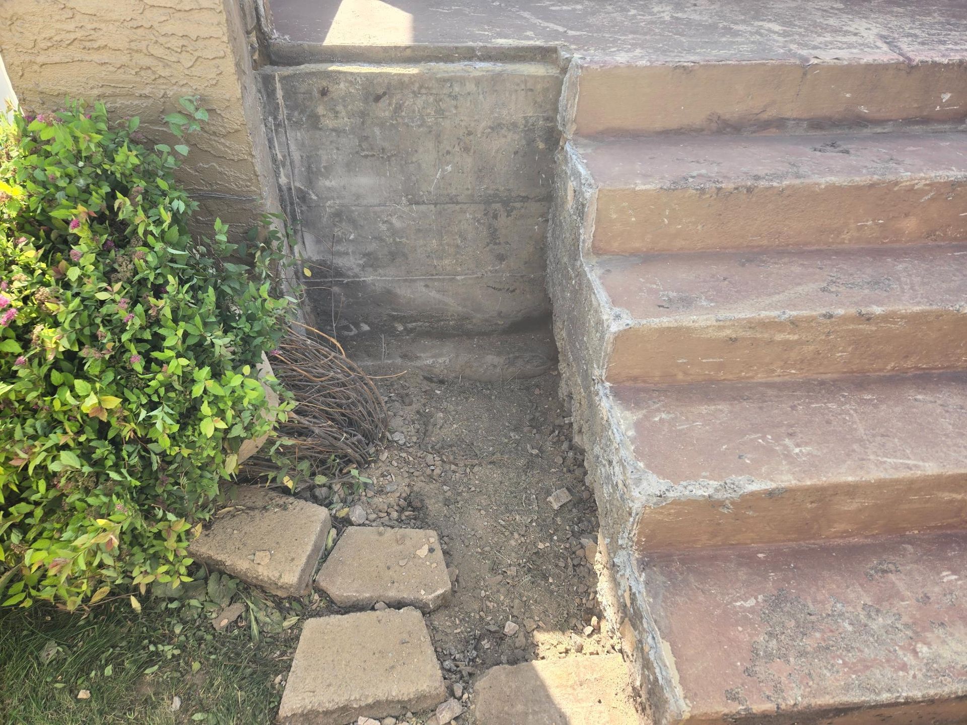 A set of stairs leading up to a concrete wall.