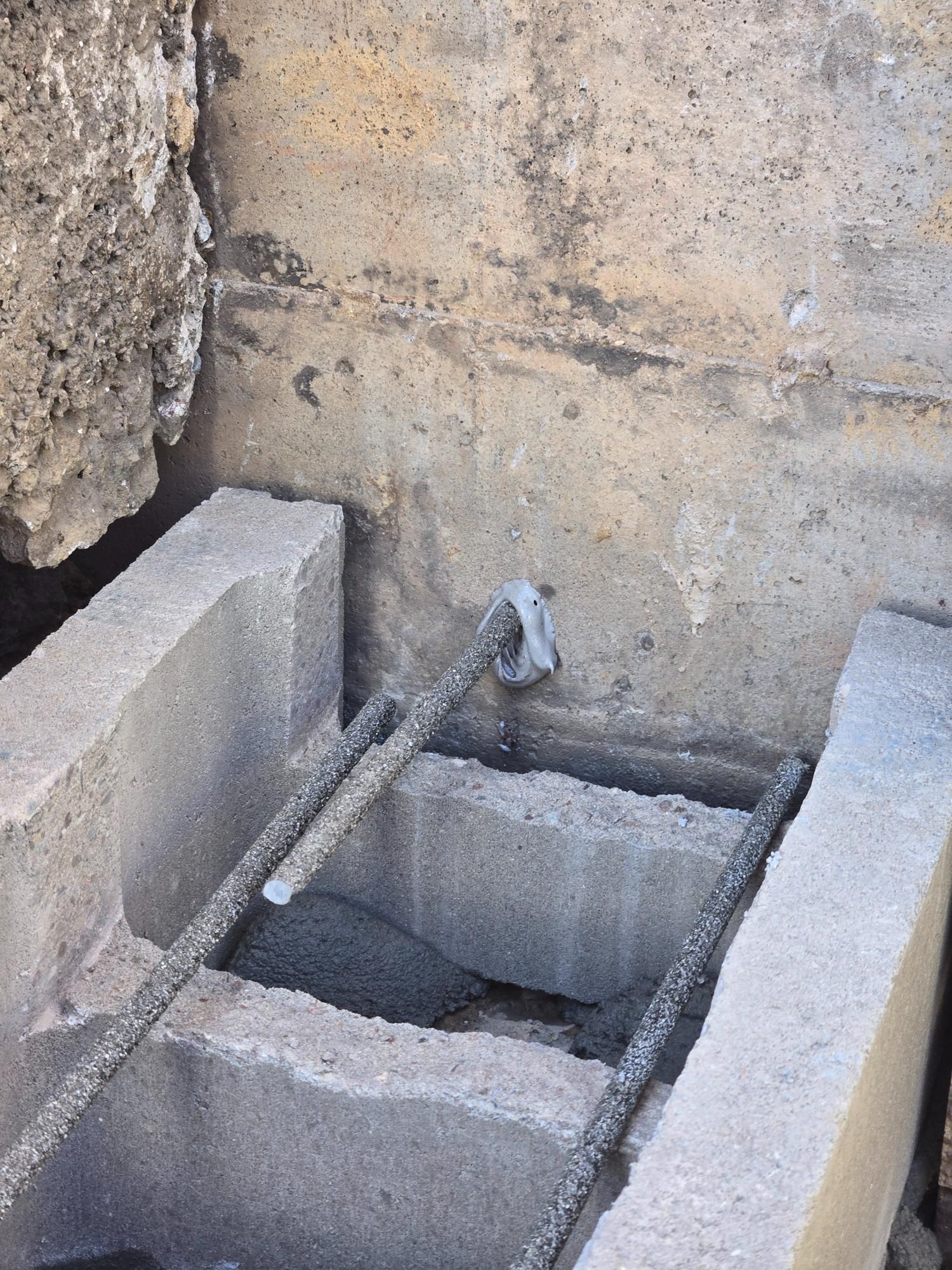 A concrete block with a metal bar attached to it.