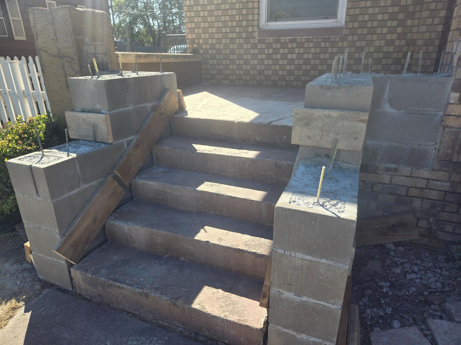 A set of concrete steps being built in front of a brick building.