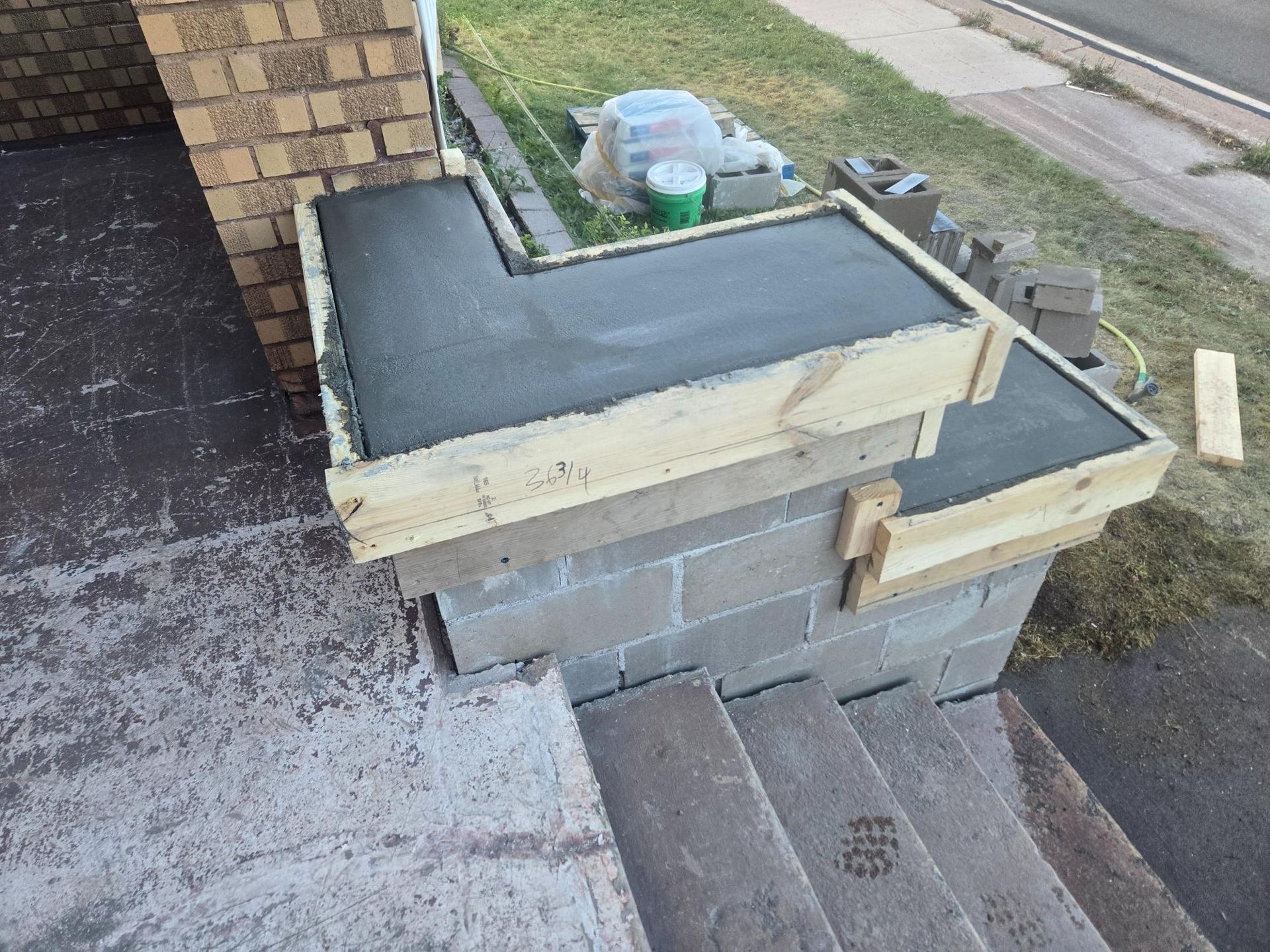 A concrete staircase is being built next to a brick wall.