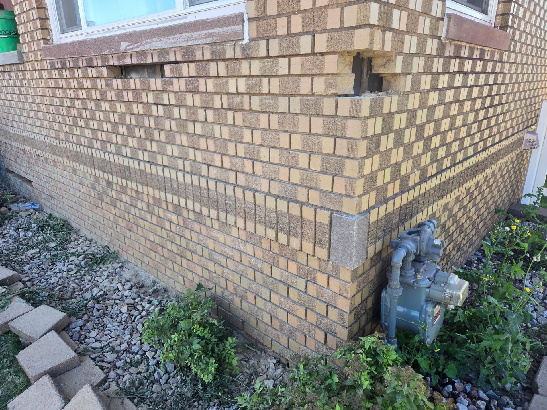 A close up of a brick wall of a house with a window.