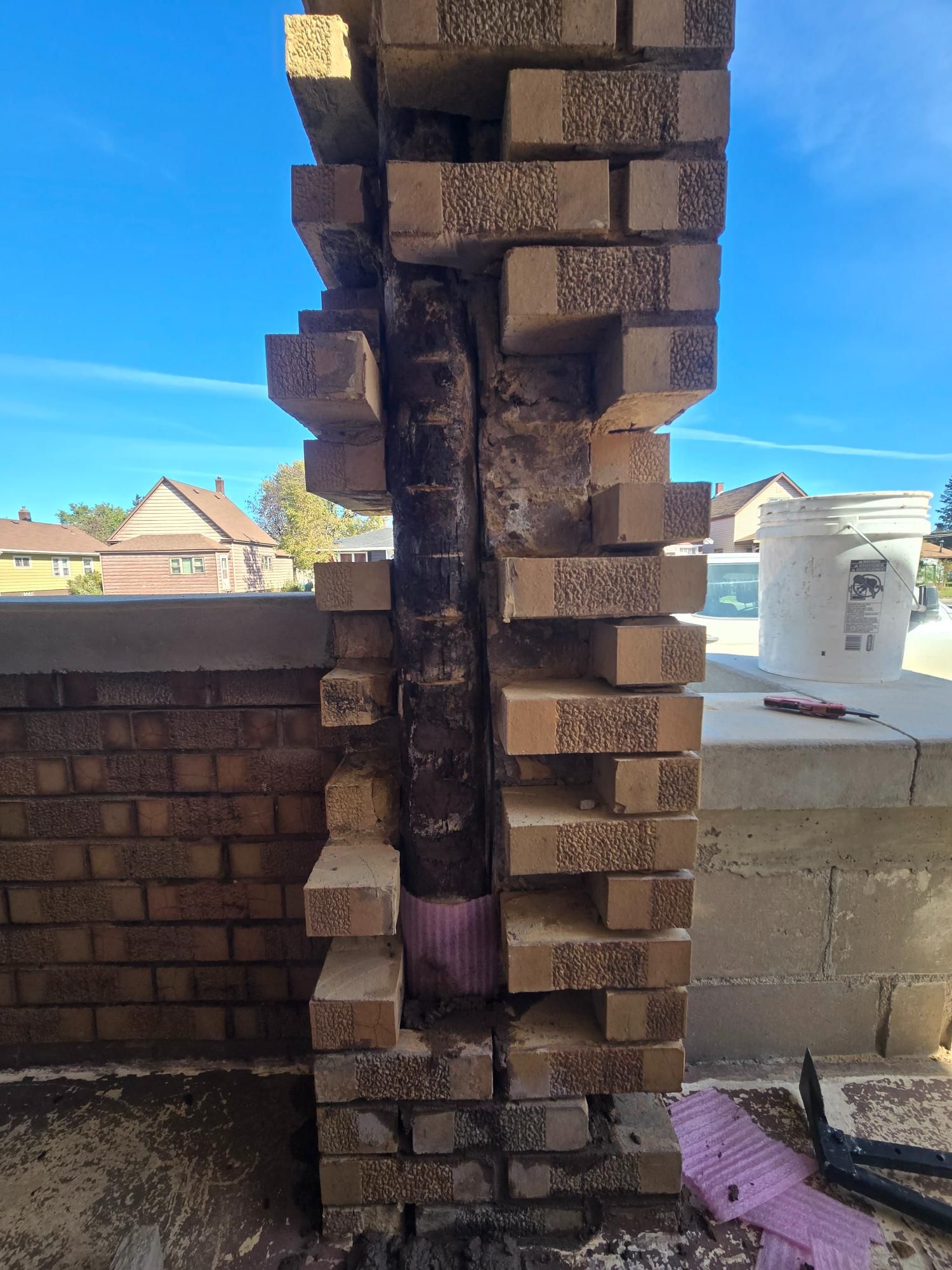 A brick wall with a hole in it and a bucket with the number 10 on it