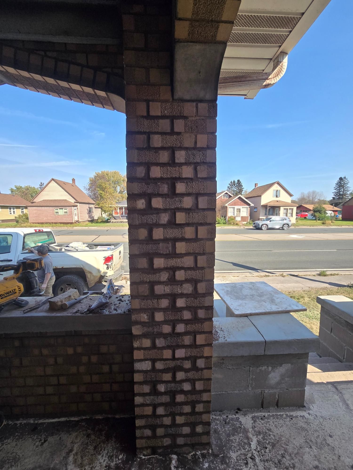 A brick column is being built on the side of a house.