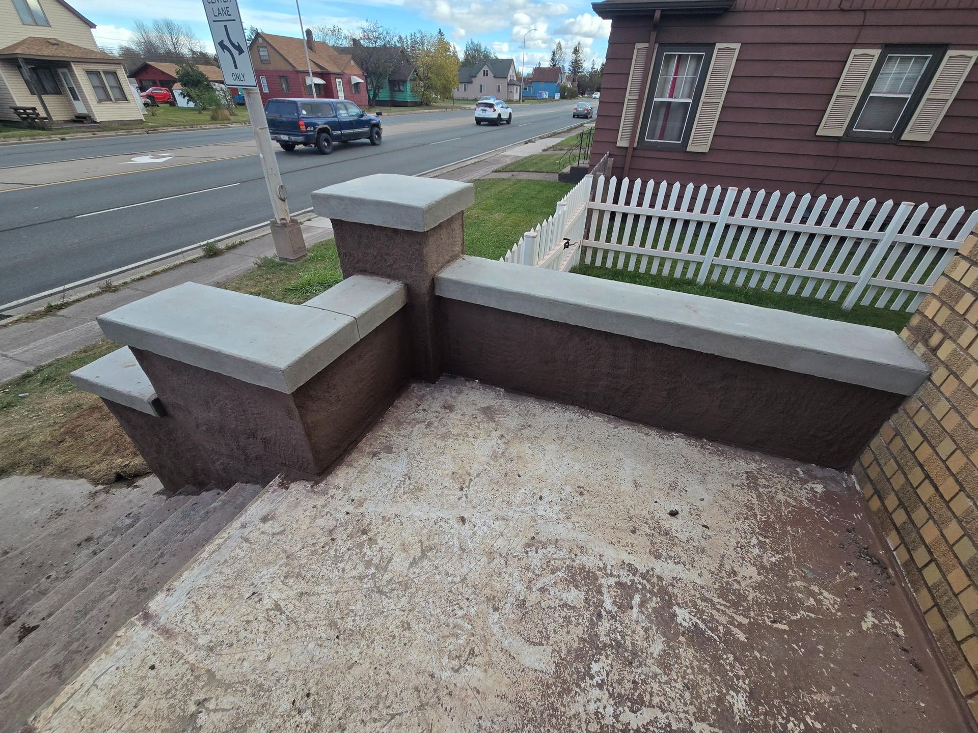 A staircase leading up to a house with a white picket fence.