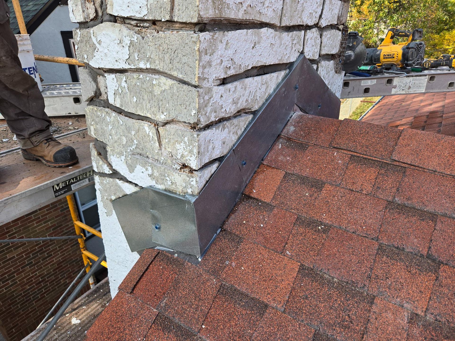 A man is working on a chimney on top of a roof.