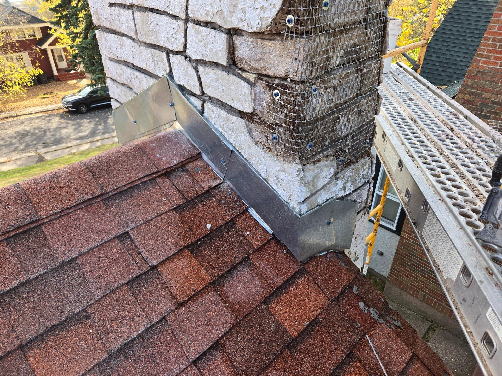 A roof with a chimney and a ladder on it.
