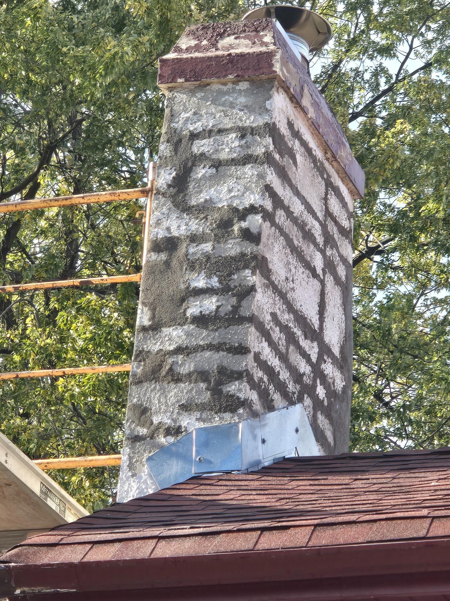 A chimney is being repaired on the side of a house.