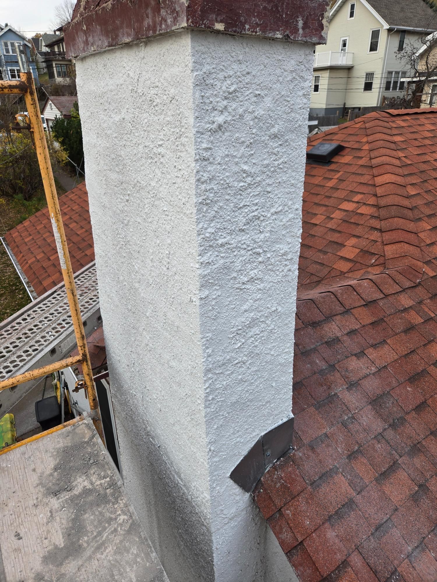 A chimney is sitting on top of a brick roof.
