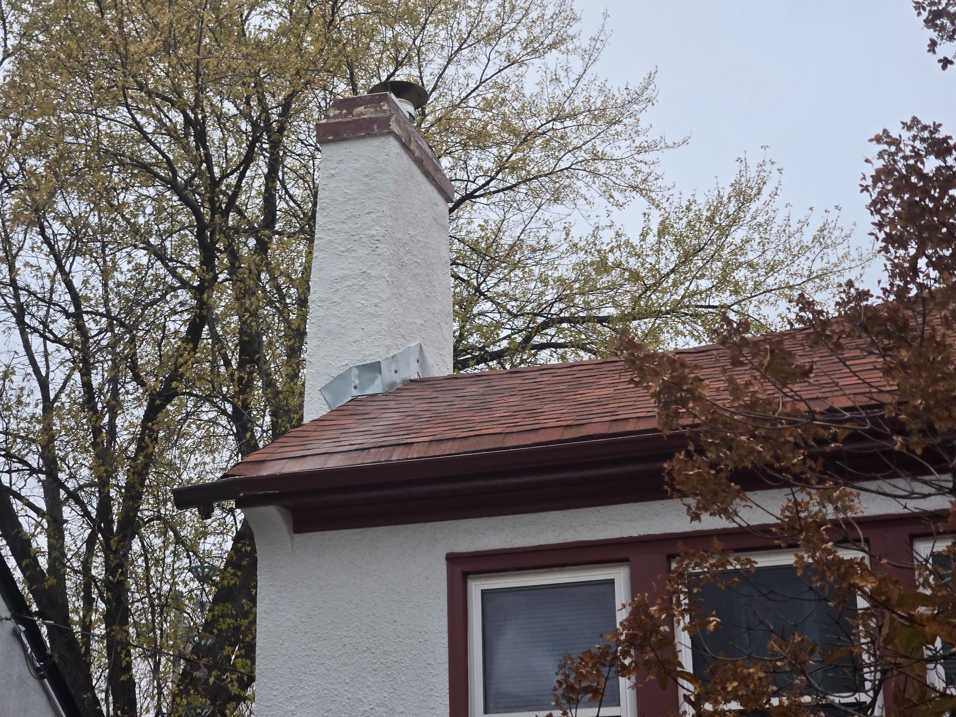 A white house with a chimney on top of it