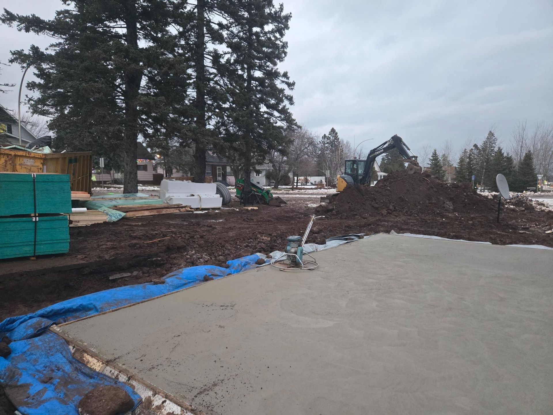 A construction site with a pile of dirt and trees in the background