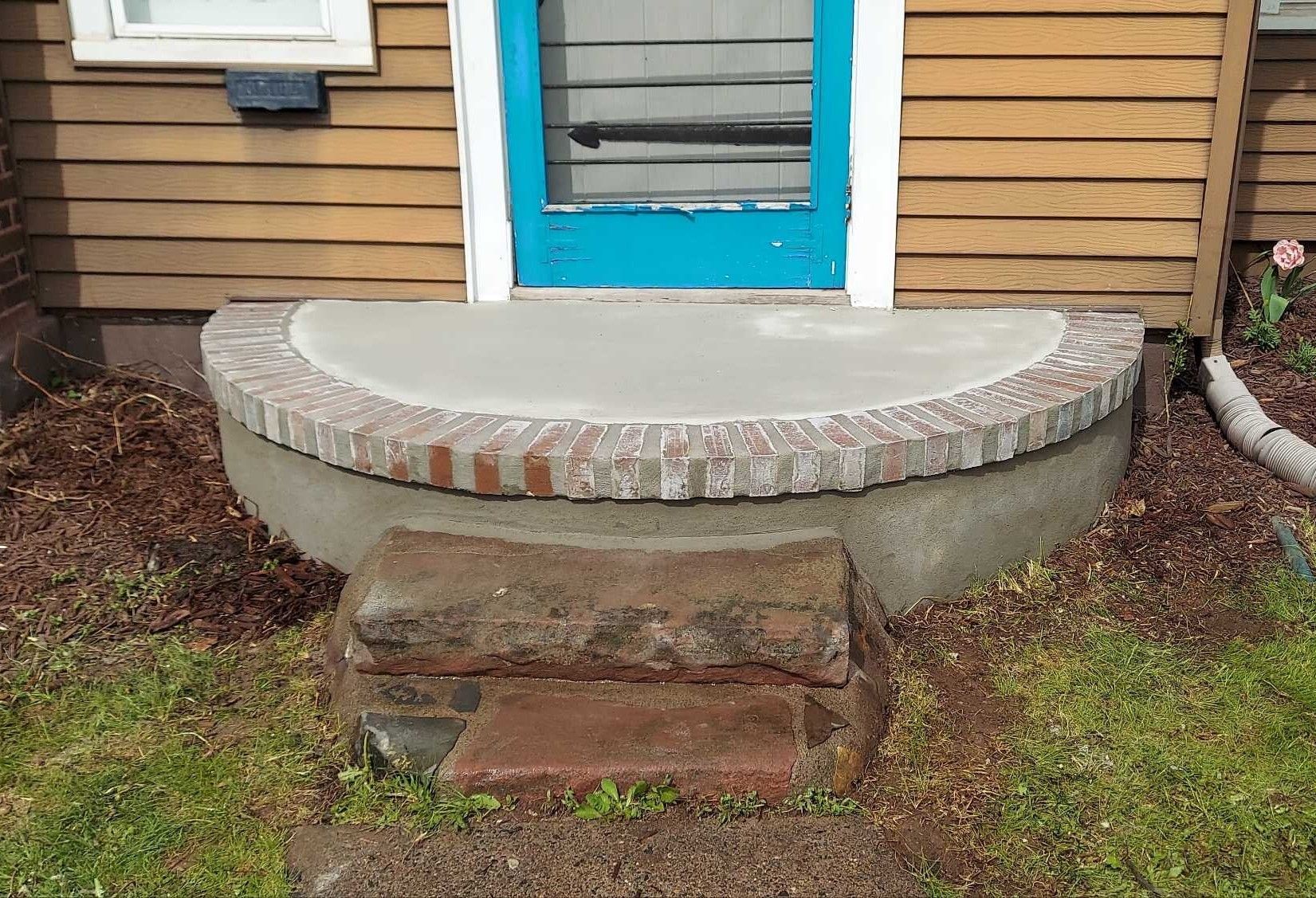 A house with a blue door and a concrete porch
