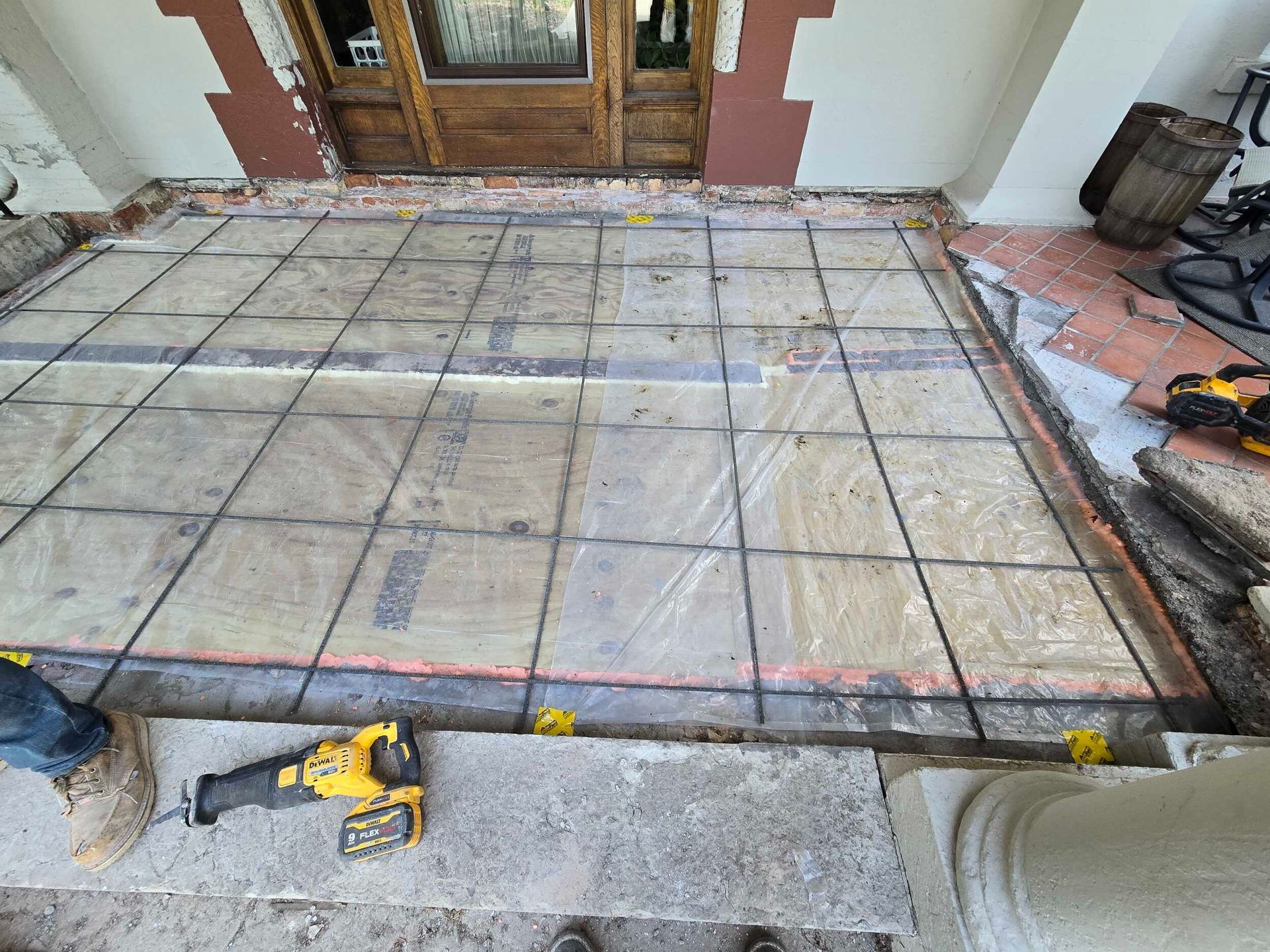 A concrete patio is being built in front of a house.