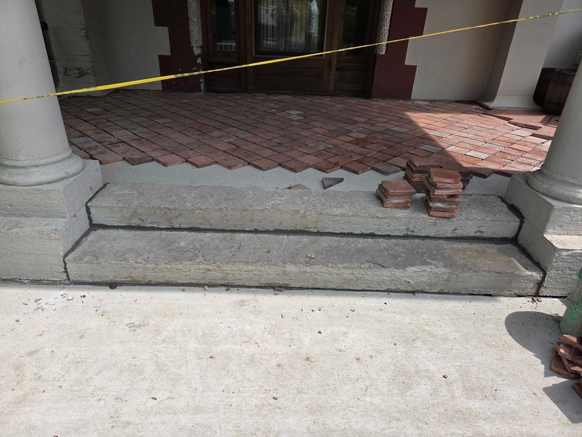 A brick walkway is being built on the side of a building