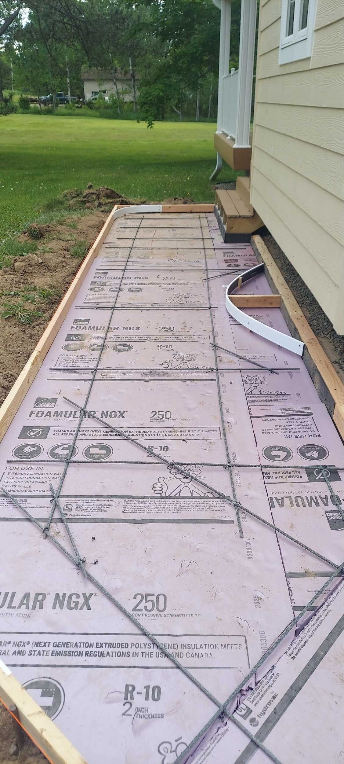 A sidewalk is being built in front of a house.