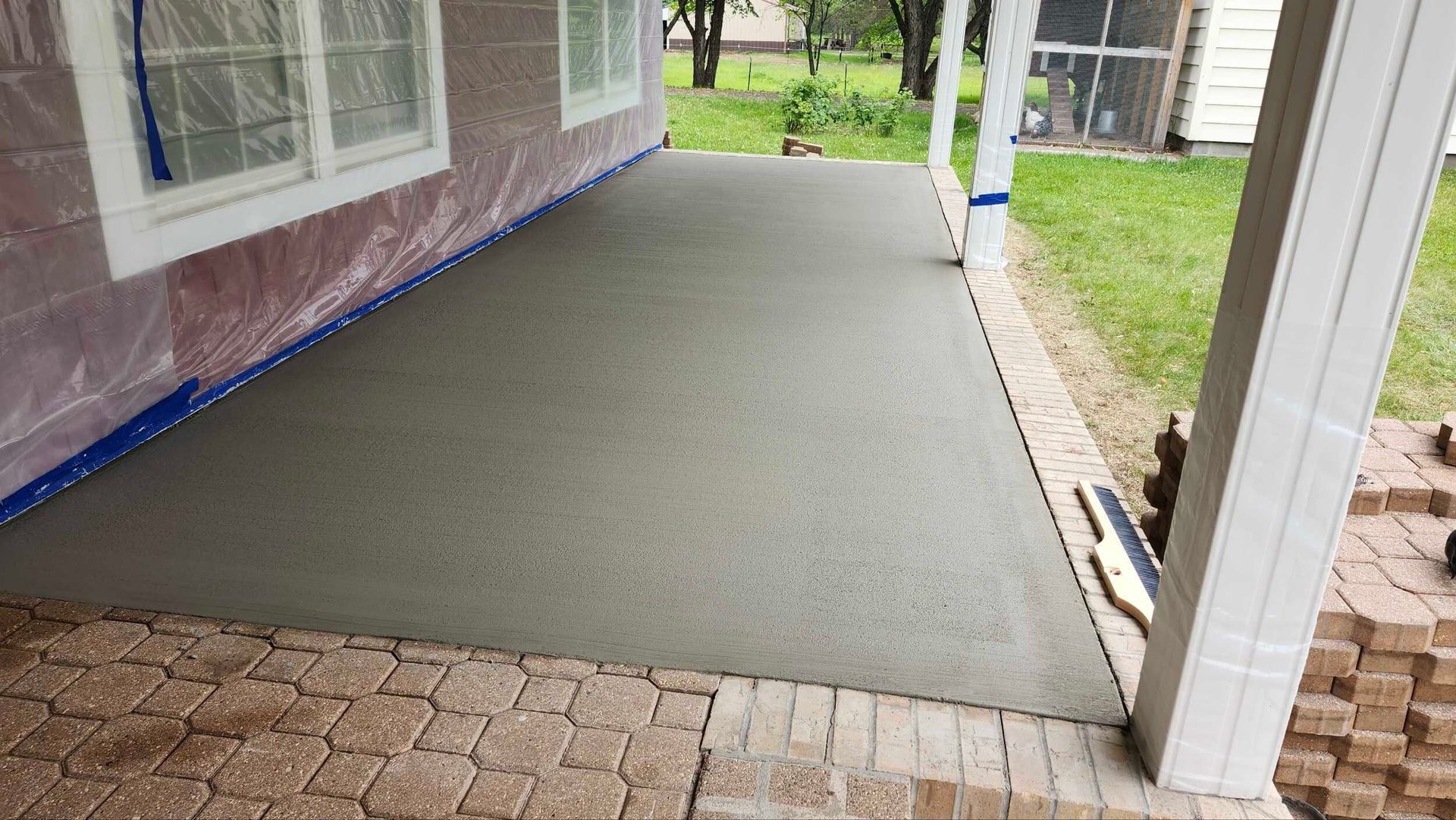 A concrete patio is being built in front of a house.