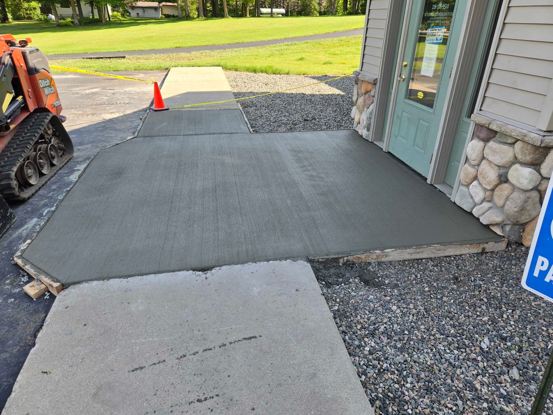 A concrete walkway is being built in front of a building.