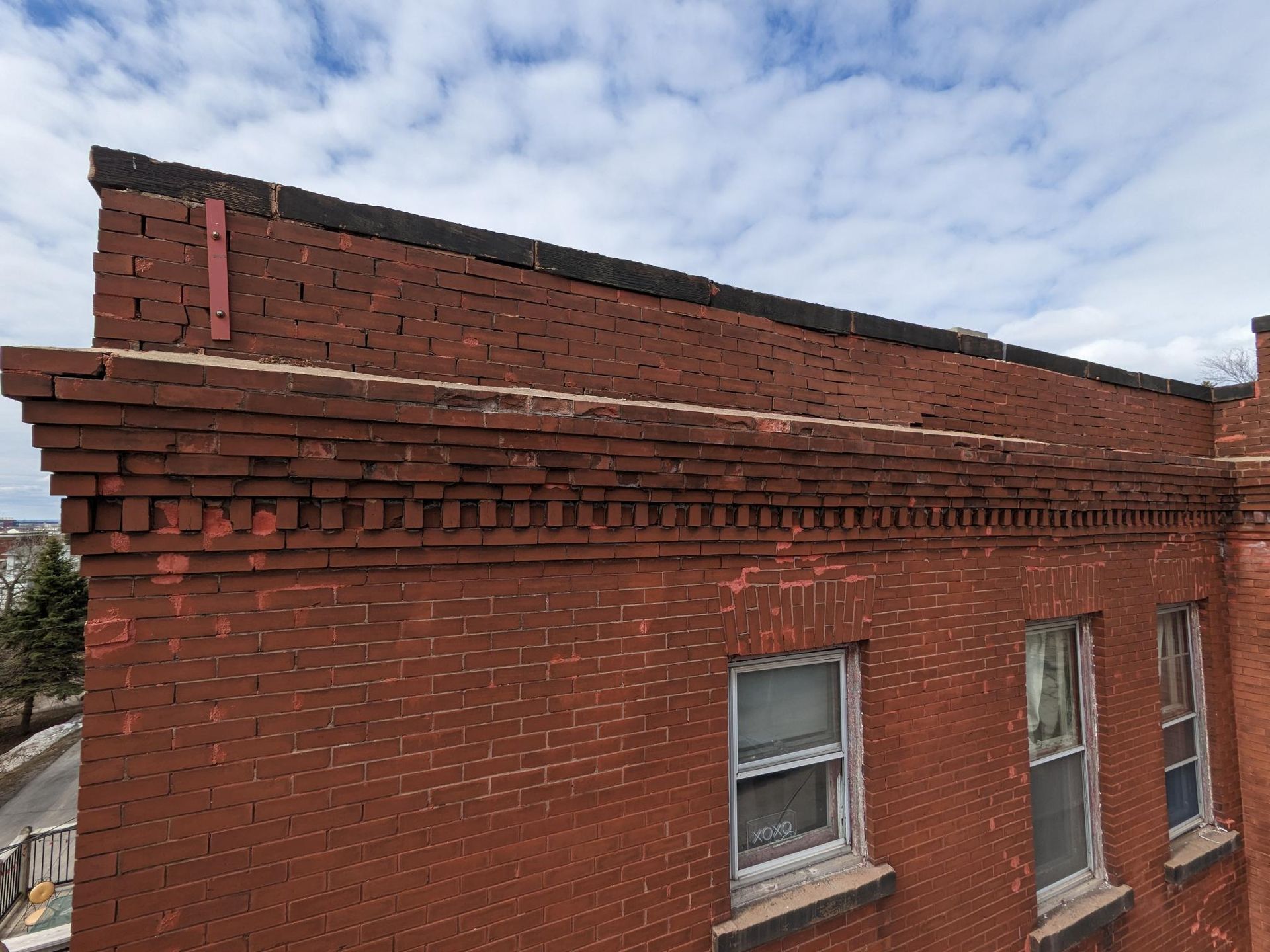 The roof of a red brick building with a lot of windows.