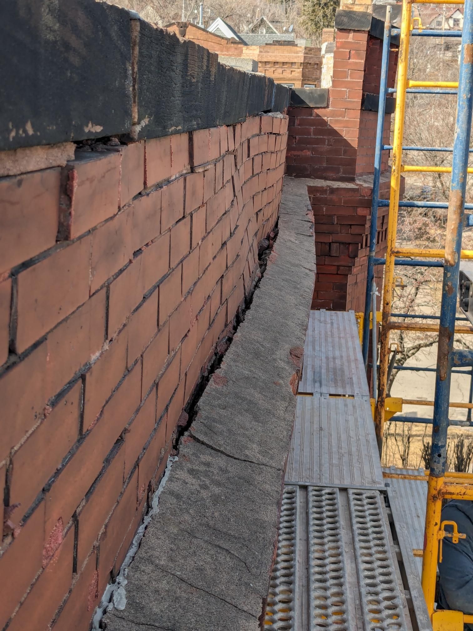 A brick wall with a scaffolding in front of it