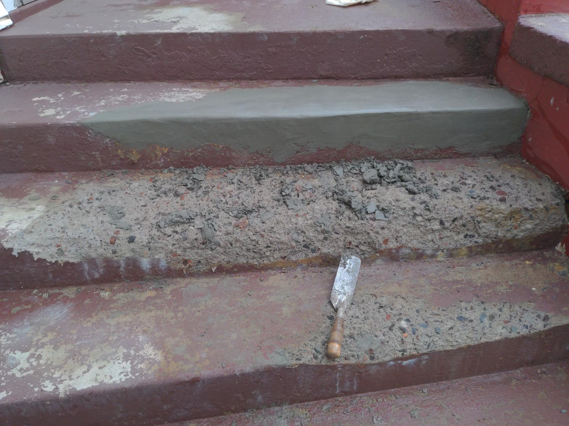 A person is laying concrete on a set of stairs.