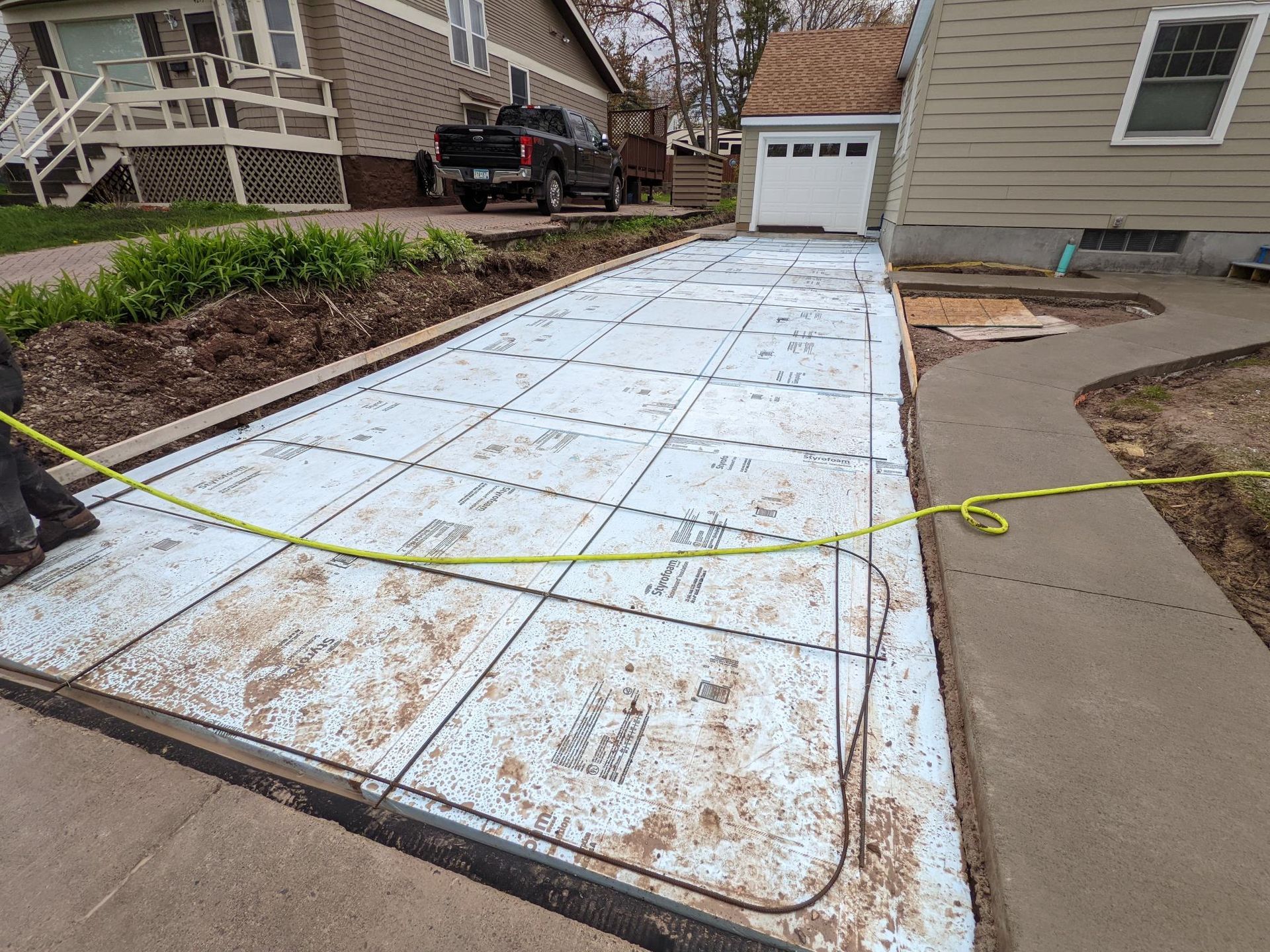 A concrete driveway is being built in front of a house.