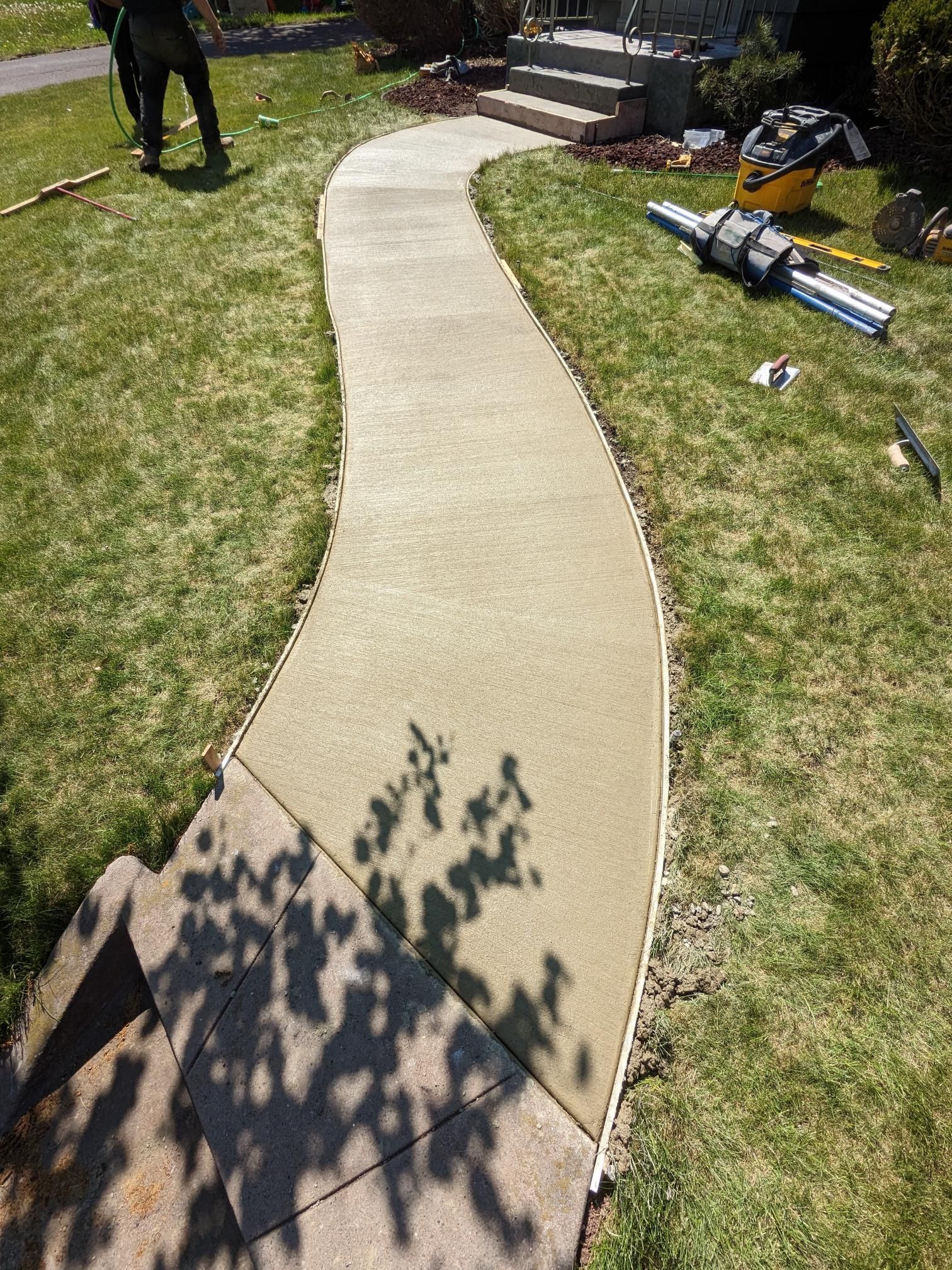 A concrete walkway is being built in a yard.