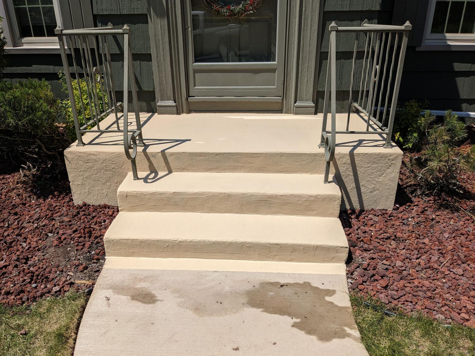 A concrete walkway with stairs leading up to a house