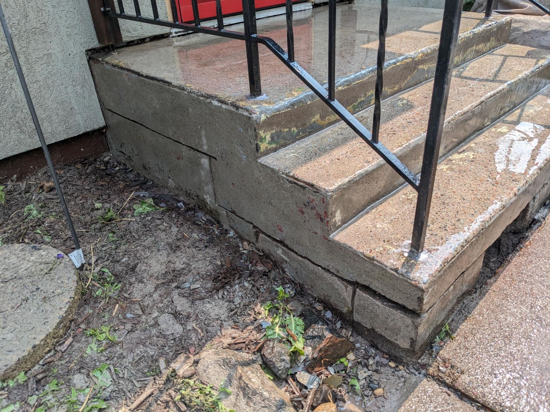 A set of stairs with a metal railing on the side of a building.